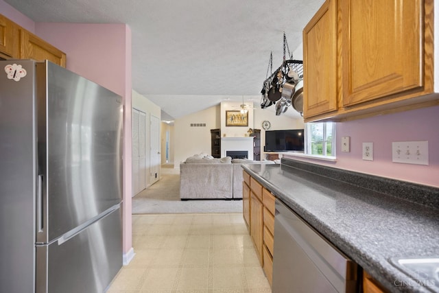 2489 Swings Corner Pt Isabel Rd, Tate Twp, OH 45106 - kitchen featuring appliances with stainless steel finishes, dark countertops, a fireplace, light floors, and brown cabinets