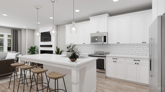 5003 Anderson Pl Unit 7, Cincinnati, OH 45227 - kitchen with appliances with stainless steel finishes, light wood-style floors, backsplash, a center island, and a breakfast bar area