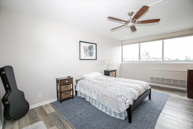 2324 Madison Rd Unit 506, Cincinnati, OH 45208 - bedroom featuring radiator, wood finished floors, baseboards, and ceiling fan