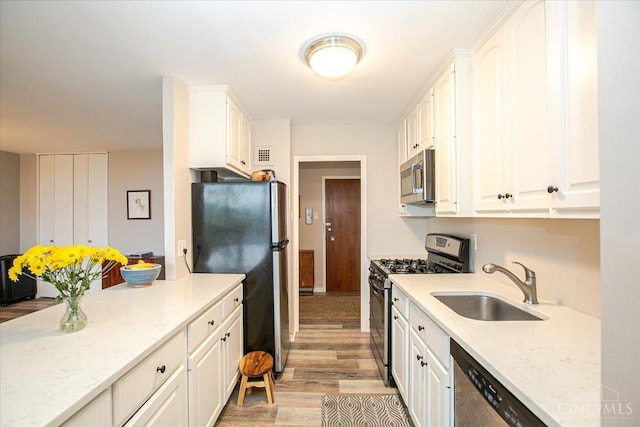 2324 Madison Rd Unit 506, Cincinnati, OH 45208 - kitchen featuring stainless steel appliances, a sink, light wood finished floors, and white cabinets