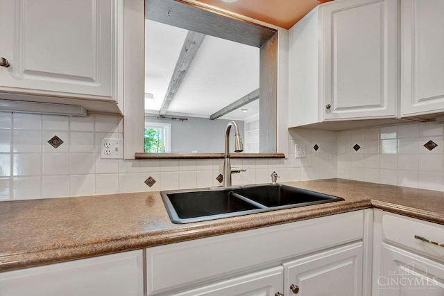 8714 Wuest Rd, Colerain Twp, OH 45251 - kitchen featuring a sink, white cabinets, and backsplash