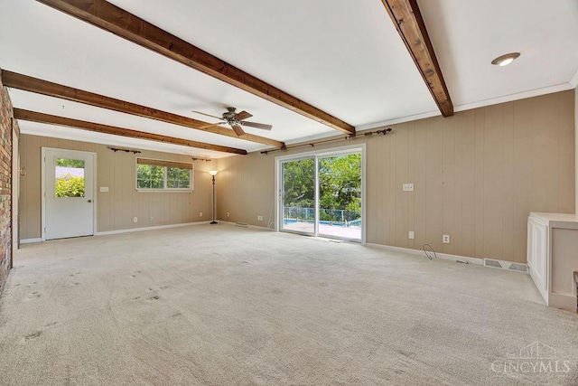 8714 Wuest Rd, Colerain Twp, OH 45251 - empty room featuring ceiling fan, beamed ceiling, baseboards, light colored carpet, and wood walls