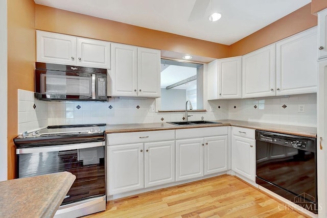 8714 Wuest Rd, Colerain Twp, OH 45251 - kitchen featuring black appliances, a sink, decorative backsplash, and white cabinetry