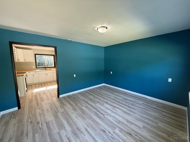 5776 State Route 132, Stonelick Twp, OH 45103 - empty room featuring light wood-style floors, baseboards, and a sink