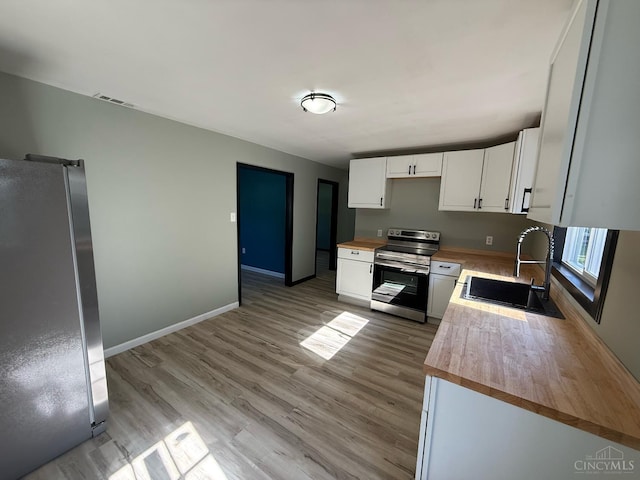 5776 State Route 132, Stonelick Twp, OH 45103 - kitchen with appliances with stainless steel finishes, a sink, butcher block countertops, and white cabinets