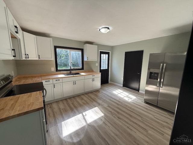 5776 State Route 132, Stonelick Twp, OH 45103 - kitchen with butcher block countertops, appliances with stainless steel finishes, a sink, light wood-style floors, and baseboards