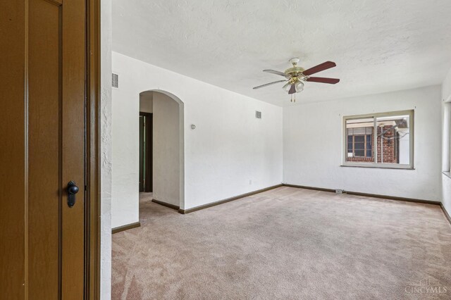 3366 Wunder Ave, Cincinnati, OH 45211 - empty room with arched walkways, light colored carpet, ceiling fan, a textured ceiling, and baseboards