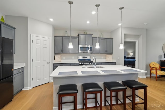 5014 S Castle Ct, Liberty Twp, OH 45011 - kitchen featuring appliances with stainless steel finishes, a sink, gray cabinets, a kitchen breakfast bar, and recessed lighting