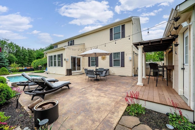 1171 Craig Ct, Hamilton Twp, OH 45039 - back of property featuring an outdoor pool, a wooden deck, outdoor dining area, and a patio