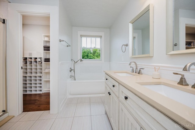 1171 Craig Ct, Hamilton Twp, OH 45039 - bathroom featuring a garden tub, double vanity, tile patterned flooring, a spacious closet, and a textured ceiling