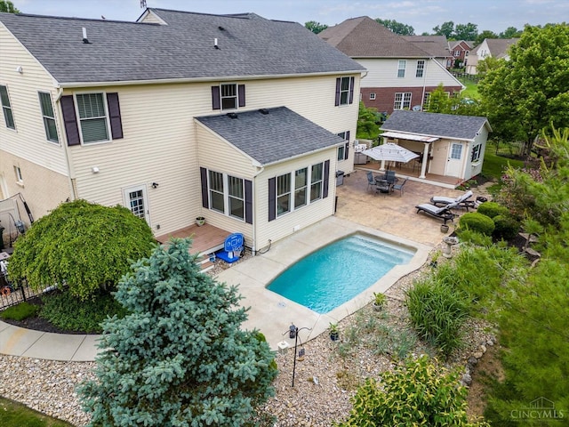 1171 Craig Ct, Hamilton Twp, OH 45039 - rear view of property featuring a wooden deck, an outbuilding, an outdoor pool, outdoor dining space, and roof with shingles