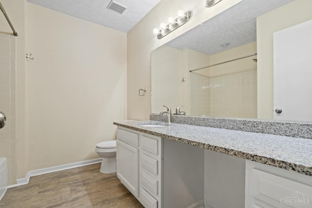 2020 Woodcreek Dr, Fairfield, OH 45014 - full bathroom with toilet, bathtub / shower combination, vanity, wood finished floors, and a textured ceiling