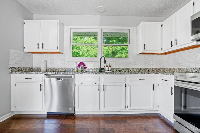 2020 Woodcreek Dr, Fairfield, OH 45014 - kitchen with stainless steel appliances, dark stone countertops, a textured ceiling, white cabinetry, and a sink