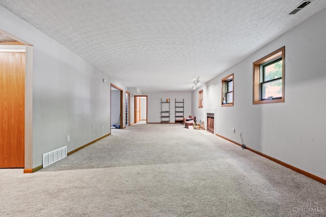 2020 Woodcreek Dr, Fairfield, OH 45014 - unfurnished room with carpet floors, a fireplace, baseboards, and a textured ceiling