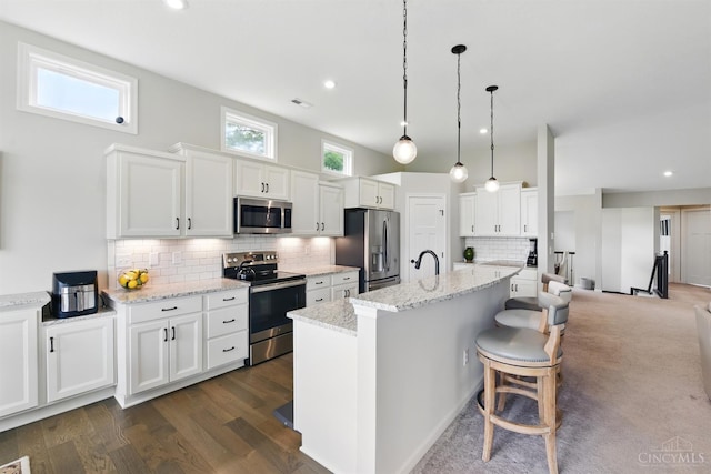 1387 Lake Run Dr, Turtle Creek Twp, OH 45036 - kitchen featuring appliances with stainless steel finishes, backsplash, white cabinets, a kitchen bar, and light stone countertops