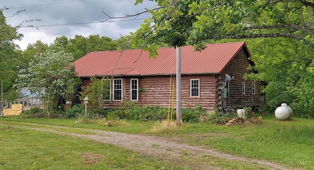 1182 Hook Morgan Rd, Concord Twp, OH 45679 - view of home's exterior featuring log exterior, a lawn, and metal roof