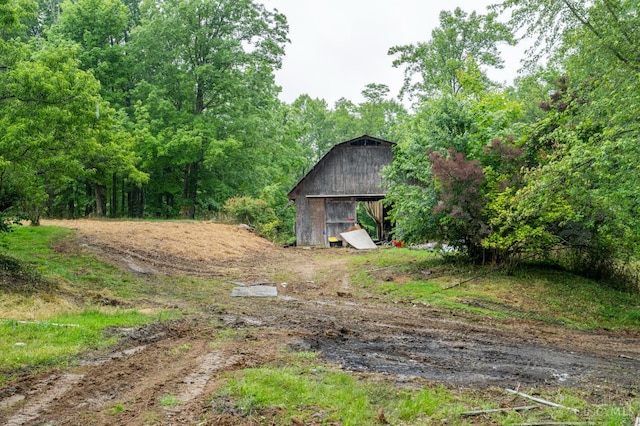 1182 Hook Morgan Rd, Concord Twp, OH 45679 - view of yard featuring a barn, an outbuilding, and a wooded view