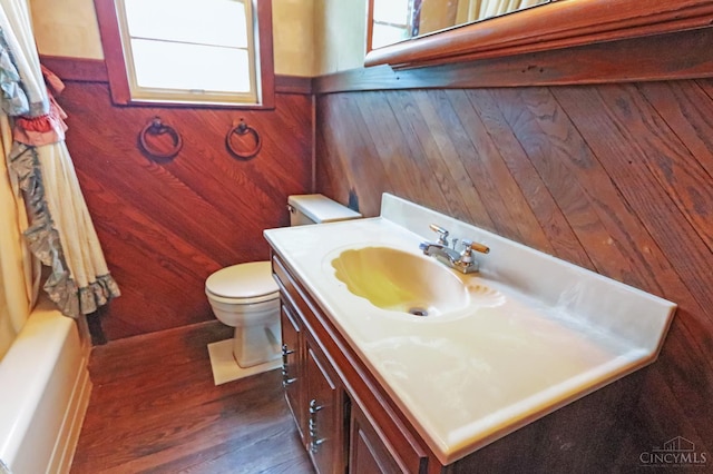 738 Clough Pike, Union Twp, OH 45245 - bathroom featuring plenty of natural light, wood finished floors, toilet, vanity, and wood walls
