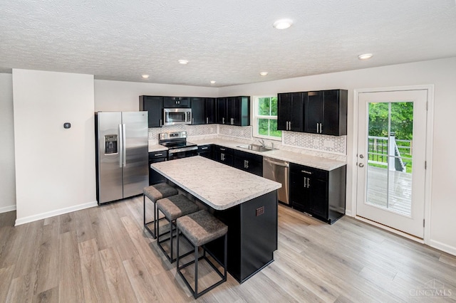 6482 Tralee Ln, Goshen Twp, OH 45122 - kitchen featuring stainless steel appliances, dark cabinetry, a kitchen island, a breakfast bar area, and recessed lighting
