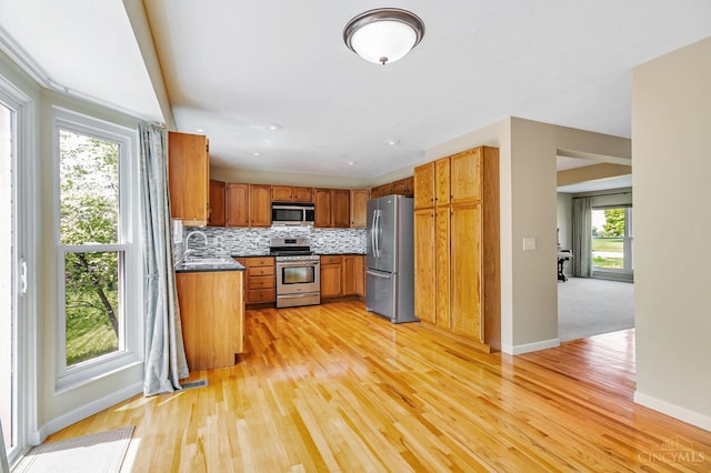4600 Blainfield Ct, Union Twp, OH 45103 - kitchen featuring appliances with stainless steel finishes, baseboards, light wood-type flooring, decorative backsplash, and brown cabinets