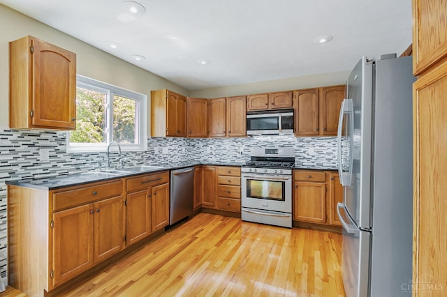 4600 Blainfield Ct, Union Twp, OH 45103 - kitchen with stainless steel appliances, a sink, light wood finished floors, tasteful backsplash, and brown cabinets