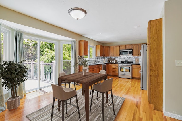 4600 Blainfield Ct, Union Twp, OH 45103 - kitchen featuring appliances with stainless steel finishes, decorative backsplash, light wood-style floors, brown cabinetry, and a sink