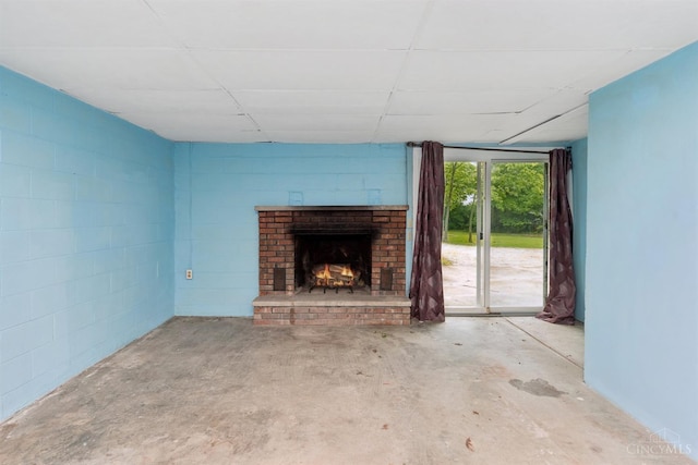 9488 Daugherty Marks Rd, Clark Twp, OH 45130 - unfurnished living room with unfinished concrete flooring, a fireplace, and concrete block wall