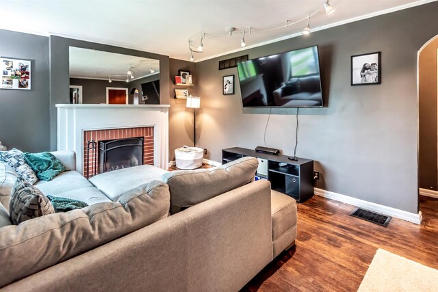 5411 Lester Rd, Cincinnati, OH 45213 - living area featuring track lighting, wood finished floors, baseboards, arched walkways, and a fireplace
