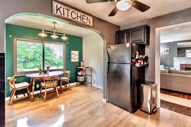 5411 Lester Rd, Cincinnati, OH 45213 - kitchen featuring freestanding refrigerator, arched walkways, light wood-style flooring, a ceiling fan, and baseboards
