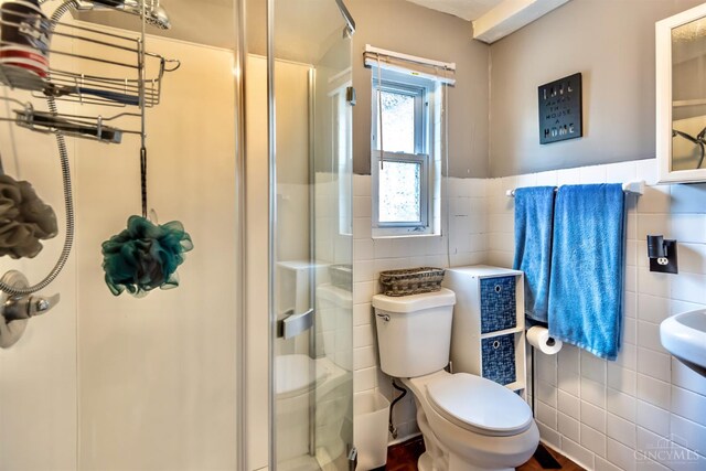 5411 Lester Rd, Cincinnati, OH 45213 - full bathroom featuring tile walls, a shower stall, toilet, and a wainscoted wall