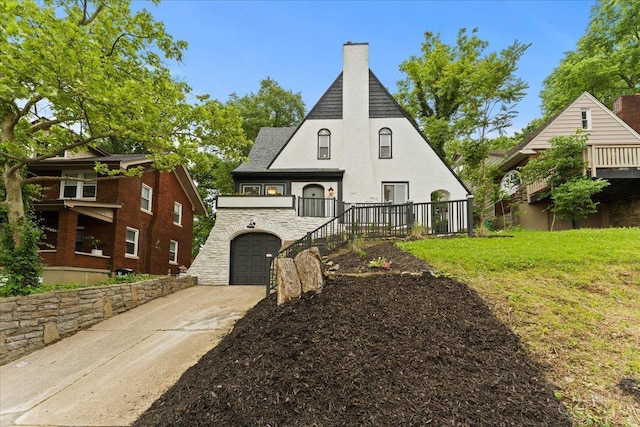 3970 Abington Ave, Cincinnati, OH 45229 - view of front facade featuring a chimney, an attached garage, concrete driveway, stone siding, and stucco siding