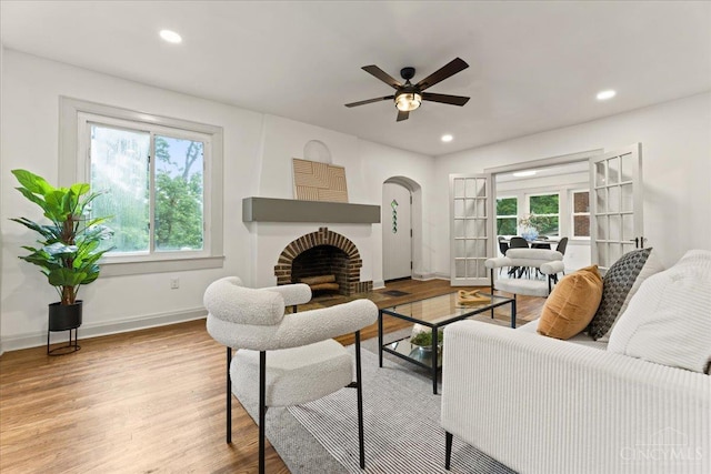 3970 Abington Ave, Cincinnati, OH 45229 - living area featuring wood finished floors, a ceiling fan, a brick fireplace, arched walkways, and recessed lighting