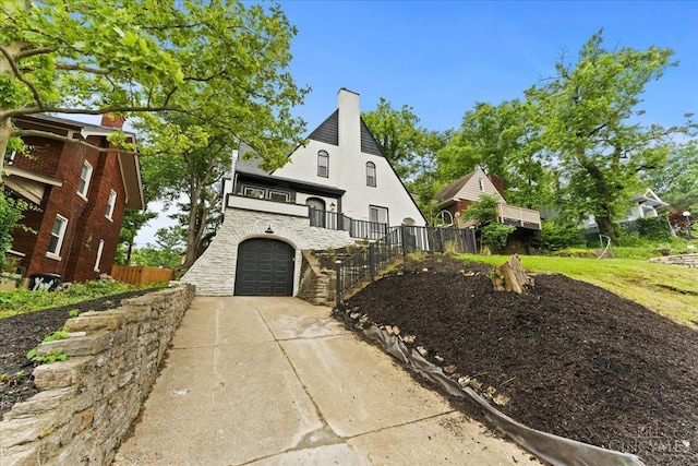 3970 Abington Ave, Cincinnati, OH 45229 - view of front of home with a garage, concrete driveway, stone siding, a chimney, and stucco siding