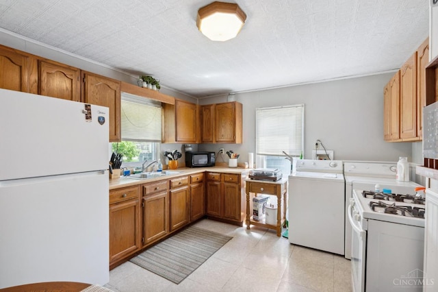 849 E Columbus St, Wilmington, OH 45177 - kitchen with white appliances, independent washer and dryer, brown cabinetry, light countertops, and a sink