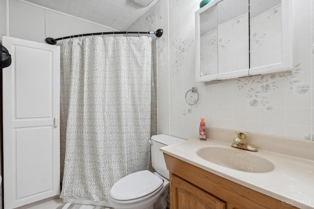 849 E Columbus St, Wilmington, OH 45177 - bathroom featuring tile walls, toilet, vanity, curtained shower, and decorative backsplash