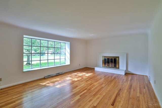 1885 Forest View Ct, Green Twp, OH 45233 - unfurnished living room with wood finished floors, a brick fireplace, and baseboards