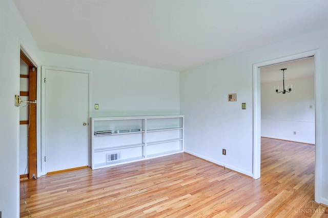 1885 Forest View Ct, Green Twp, OH 45233 - empty room with light wood finished floors, a chandelier, and baseboards