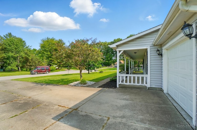 3914 Brookville Dr, Batavia Twp, OH 45102 - covered porch featuring a lawn, a garage, and concrete driveway