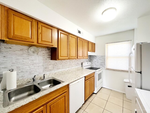 3610 Roosevelt Blvd Unit B, Middletown, OH 45044 - kitchen featuring white appliances, light countertops, a sink, light tile patterned flooring, and brown cabinetry