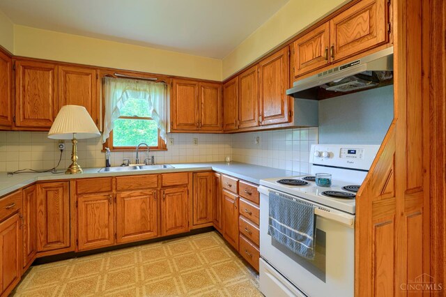 973 Umblebee Rd, Liberty Twp, OH 45613 - kitchen with white electric range oven, under cabinet range hood, a sink, brown cabinets, and light countertops