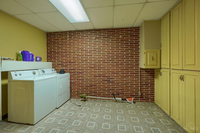 973 Umblebee Rd, Liberty Twp, OH 45613 - washroom featuring brick wall, cabinet space, and separate washer and dryer
