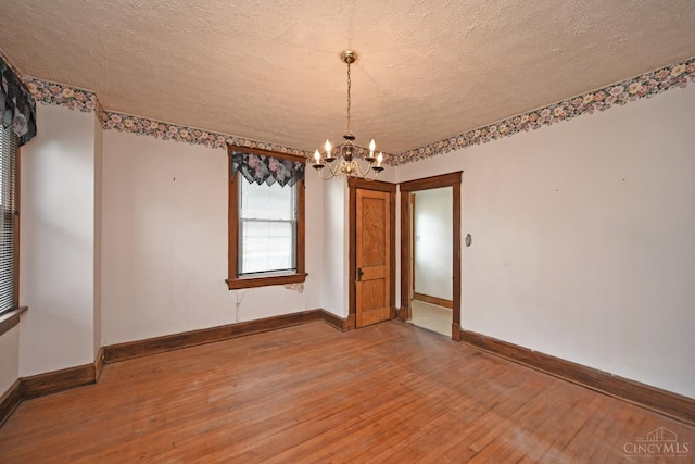 1917 Webman Ct, Cincinnati, OH 45223 - spare room featuring light wood-style floors, a chandelier, baseboards, and a textured ceiling