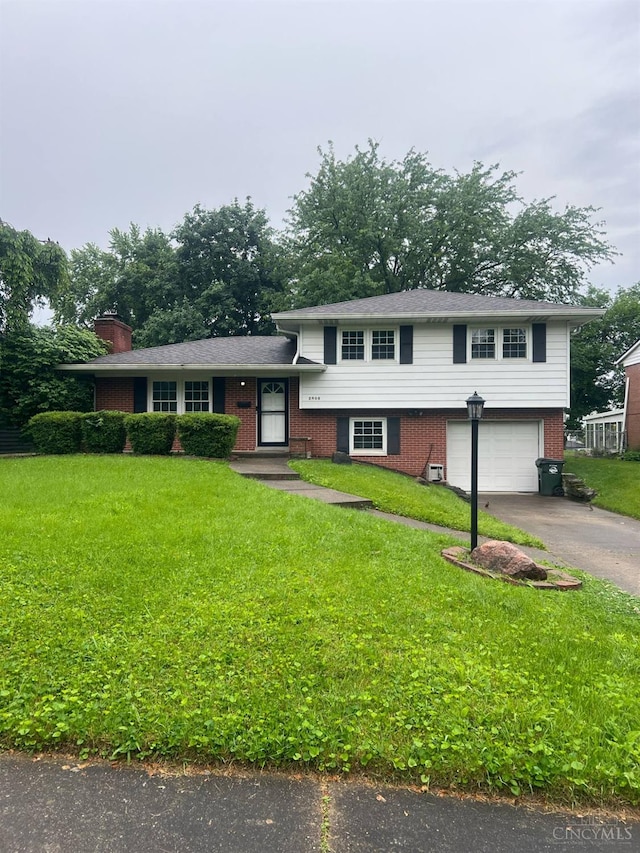2808 Lopane Ave, Middletown, OH 45044 - tri-level home with asphalt driveway, a garage, a front lawn, and brick siding