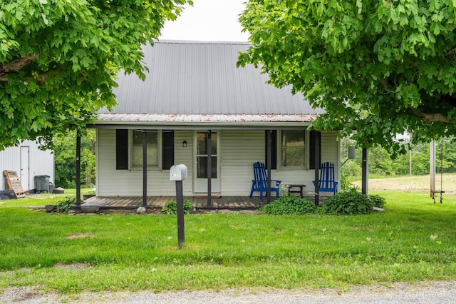 8111 E Folsom Rd, Washington Twp, OH 45133 - view of front of house with covered porch, a front yard, and a metal roof