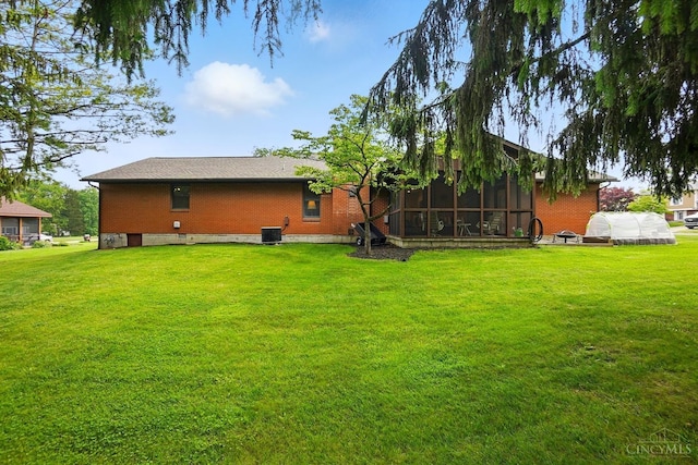 21 Garden Cir, Wilmington, OH 45177 - back of house with an exterior structure, a sunroom, a yard, brick siding, and an outbuilding