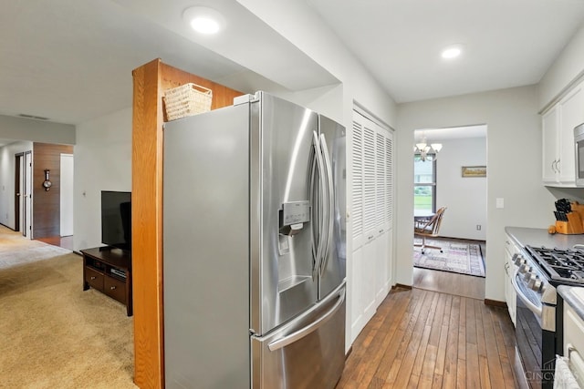21 Garden Cir, Wilmington, OH 45177 - kitchen with appliances with stainless steel finishes, a chandelier, hardwood / wood-style flooring, white cabinets, and baseboards