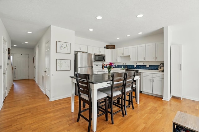 943 Steamboat Dr Unit 204, Union Twp, OH 45244 - kitchen with appliances with stainless steel finishes, light wood-style floors, recessed lighting, baseboards, and white cabinetry