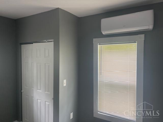 4 Cottage Ct, Anderson Twp, OH 45230 - unfurnished bedroom featuring a wall mounted air conditioner and a closet