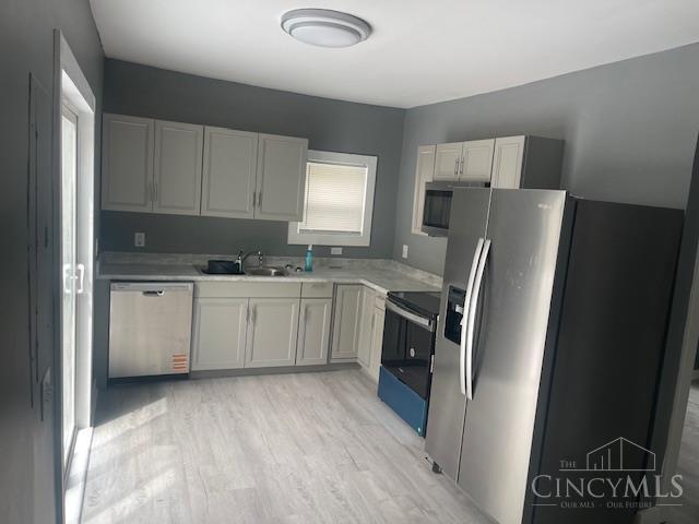 4 Cottage Ct, Anderson Twp, OH 45230 - kitchen featuring appliances with stainless steel finishes, a sink, light countertops, and light wood-style flooring