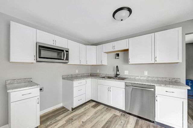 8486 US Route 127, West Manchester, OH 45382 - kitchen featuring stainless steel appliances, a sink, light wood-style floors, white cabinets, and light countertops